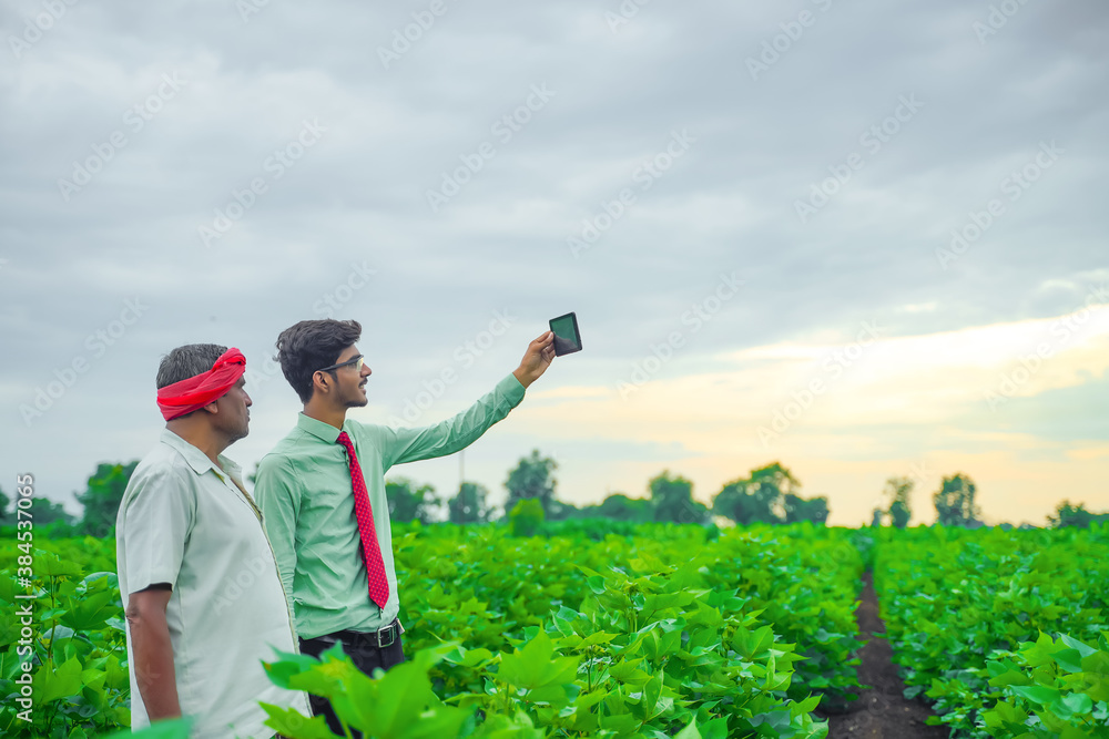 Young indian agronomist taking selfie with farmer at field Young indian agronomist taking selfie with farmer at field