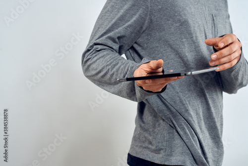 Man with tablet in hands technology lifestyle internet communication work light background cropped view