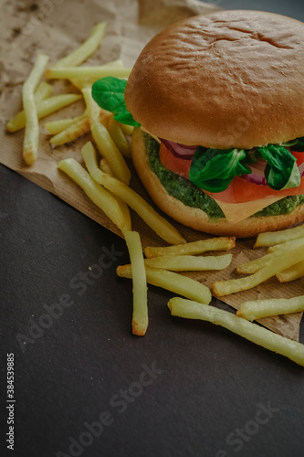 Healthy vegan spinach, tomato, arugula, onion and cheese green burger with potatoes  photo