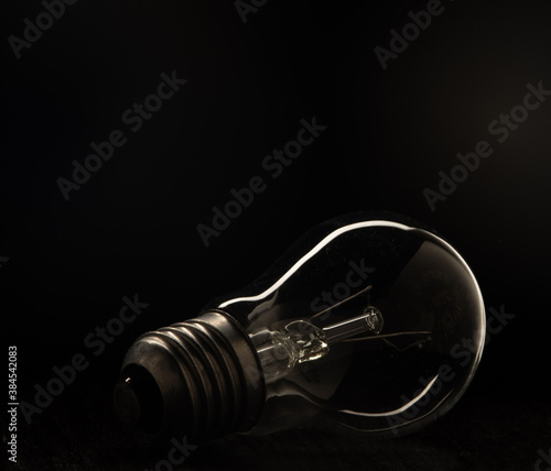 Incandescent light Incandescent light bulb with tungsten filament on a black background.