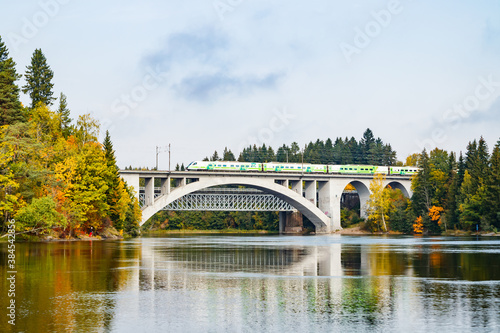 Kouvola, Finland - 25 September, 2019: Autumn landscape of bridge with moving passenger train and Kymijoki river waters in Finland, Kymenlaakso, Kouvola, Koria © Elena Noeva