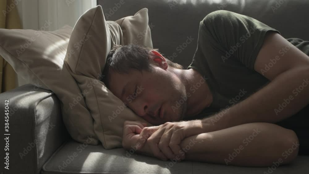Depressed sulking man lying alone at living room sofa and thinking Depressed sulking man lying alone at living room sofa and thinking