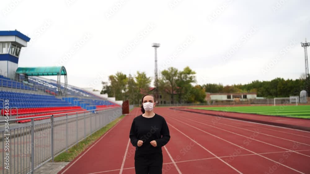 Active woman in protective mask running at stadium. Young fit female in sportswear and protective mask for coronavirus prevention running on red track during outdoor workout at stadium
Active woman in protective mask running at stadium. Young fit female in sportswear and protective mask for coronavirus prevention running on red track during outdoor workout at stadium