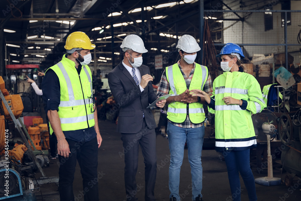 Leader or manager using tablet and meeting with engineer and technician while line walk in factory workplace, team wear face mask whine working at maintenance machine shop Leader or manager using tablet and meeting with engineer and technician while line walk in factory workplace, team wear face mask whine working at maintenance machine shop