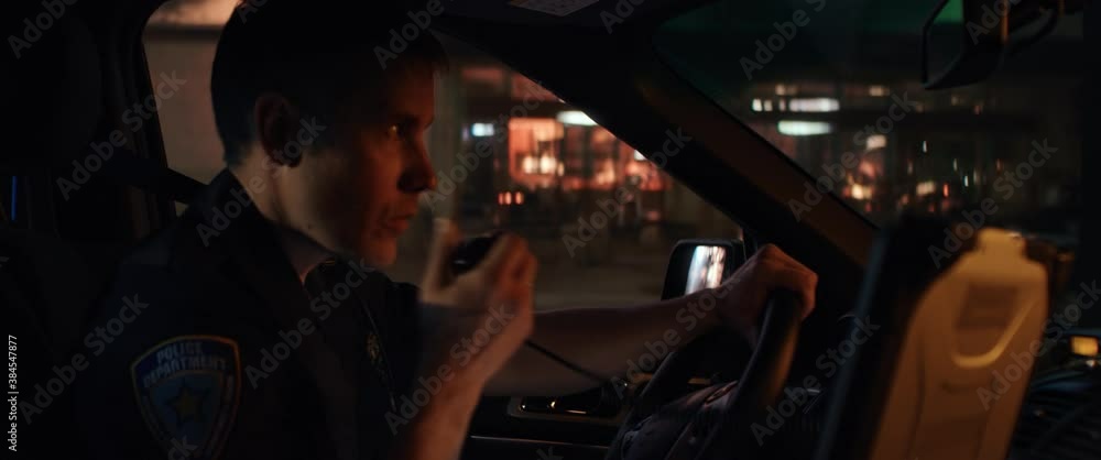 CU Portrait of police officer talking on CB radio while driving in a vehicle through city streets at night. Shot on RED Dragon with 2x Anamorphic lens CU Portrait of police officer talking on CB radio while driving in a vehicle through city streets at night. Shot on RED Dragon with 2x Anamorphic lens
