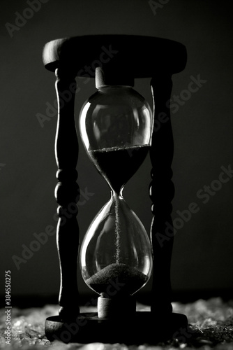 Sand clock on broken glass pieces in blur. 