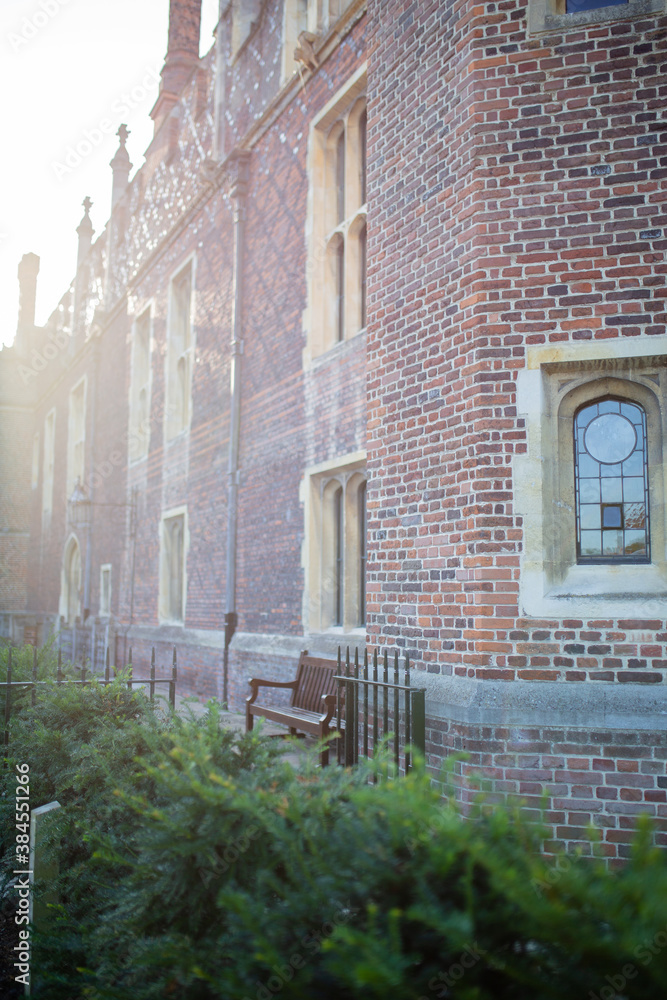 Fototapeta premium Red-Brick Building with Wooden Benches and Plants Outside