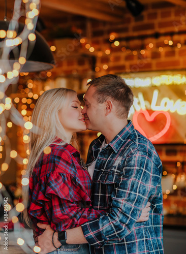 A beautiful couple man and woman hugging and kissing in the Christmas kitchen