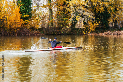 young athletic man training on his kayak canoe in autumn