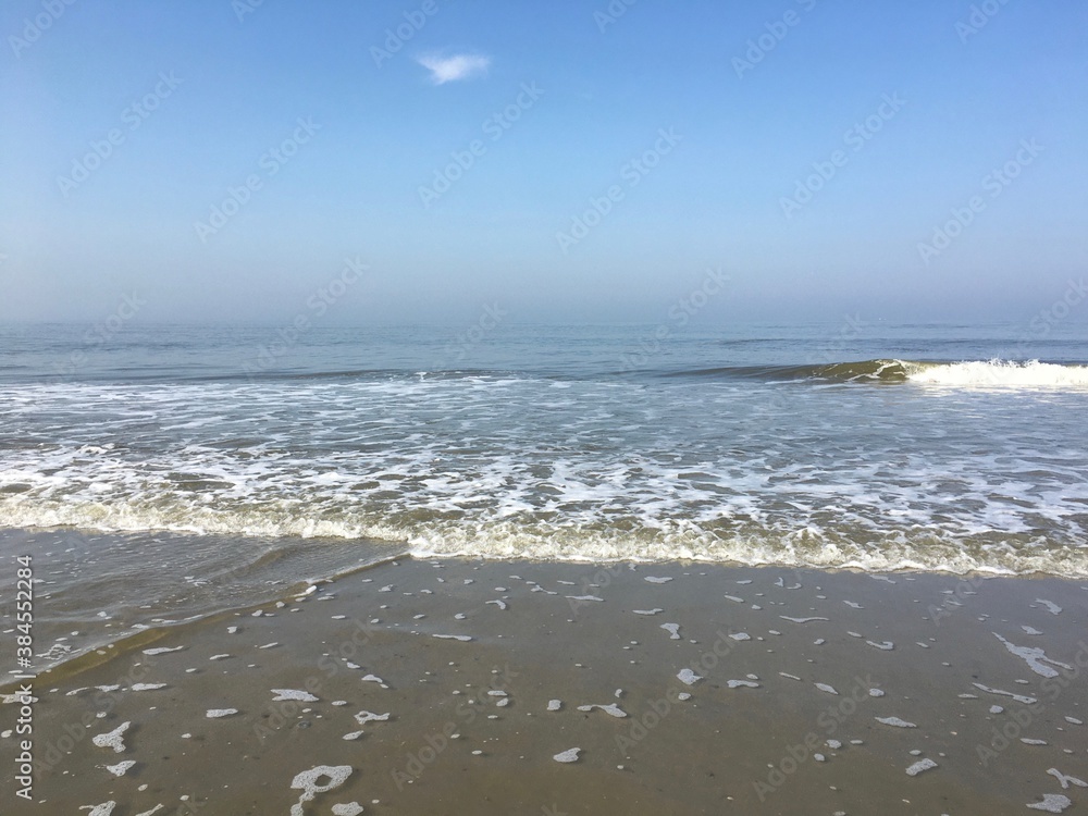 Brechende Wellen am Strand von Langeoog im Sommer