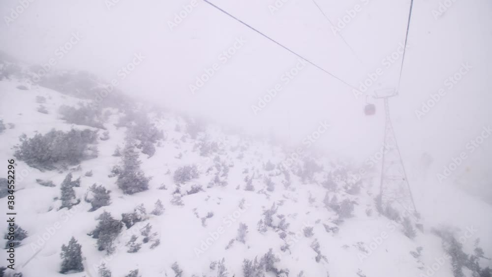 Gondola ski lift in Borovets, Bulgaria. Cabins on a steel cable on a foggy weather day. Gondola ski lift in Borovets, Bulgaria. Cabins on a steel cable on a foggy weather day.
