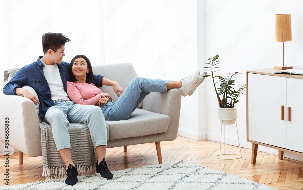 Loving Chinese Couple Relaxing Sitting On Couch At Home Loving Chinese Couple Relaxing Sitting On Couch At Home