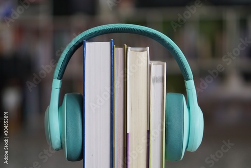 soft focus of the books stacked up with headphone on bookshelf background.