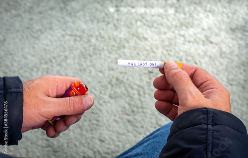 A man holding a cigarette with text 