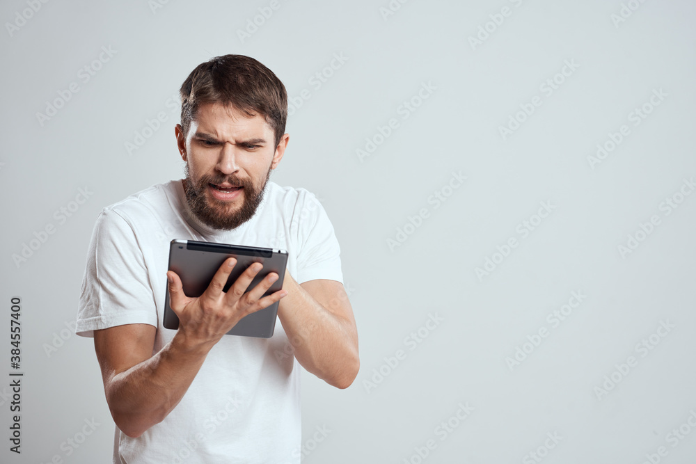 emotional man with tablet in hand touch screen new technologies light background cropped view Copy Space emotional man with tablet in hand touch screen new technologies light background cropped view Copy Space