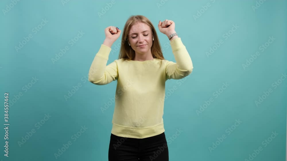 Close up of an young pretty woman dancing and posing over turquoise background. Good mood. Close up of an young pretty woman dancing and posing over turquoise background. Good mood.
