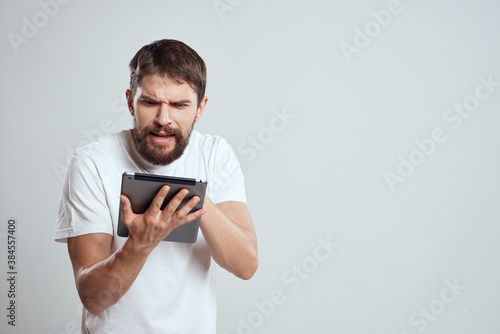 emotional man with tablet in hand touch screen new technologies light background cropped view Copy Space