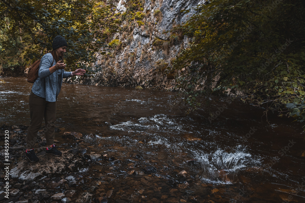 Girl looking at splash in stream water in Autumn Girl looking at splash in stream water in Autumn