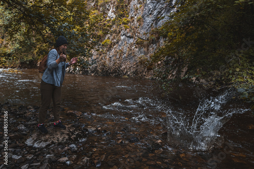 Girl throwing rock into stream and creating splash  © Jamie