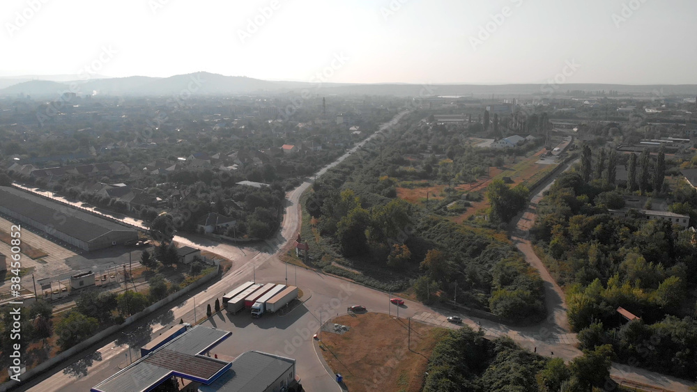 Top view of city landscape. Scenery of summer nature of small town. Narrow asphalt roads with cars.