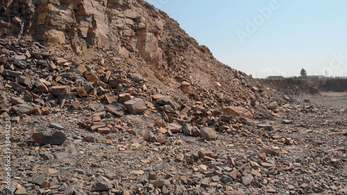 Landscape of rocky hill of quarry. Natural rock masses and layers on the surface.