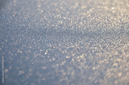 Rime on a car roof, closeup of sparkling defrosting ice