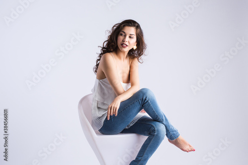 Beautiful woman posing while sitting in a modern armchair.