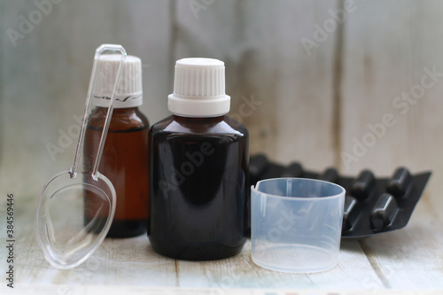 brown medicine bottle with measuring Cup and spoon