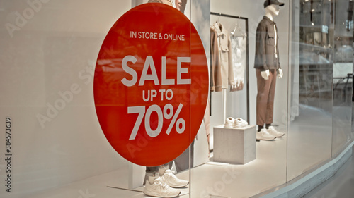 text on the red sticker on the glass in the store with the inscription sale up to 70% off