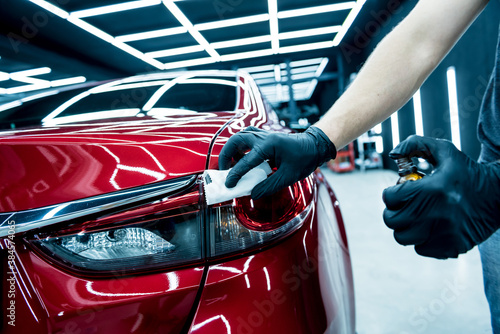 Car service worker applying nano coating on a car detail.