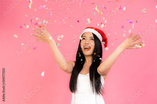 Portrait of two lovely cute asian women in christmas hats  looking at camera isolated over pink background.Attractive asian woman smile in christmas, new year, valentine day, birthday .