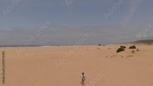 A Lone Girl Walking On The Sandy Beach In Summer At Carrapateira, Algarve, Portugal. Bordeira's Beach- aerial drone shot