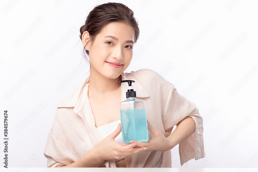Asian woman holding alcohol antiseptic gel bottle and smile isolated on white background. Asian woman holding alcohol antiseptic gel bottle and smile isolated on white background.