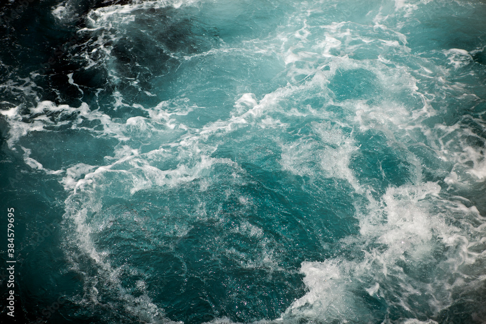 Waves and white foam at the sea. Watching the blue water building pattern. Waves and white foam at the sea. Watching the blue water building pattern.