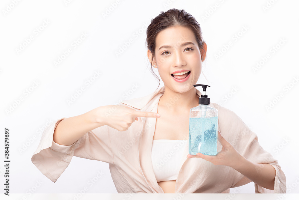 Asian woman holding alcohol antiseptic gel bottle and smile isolated on white background. Asian woman holding alcohol antiseptic gel bottle and smile isolated on white background.
