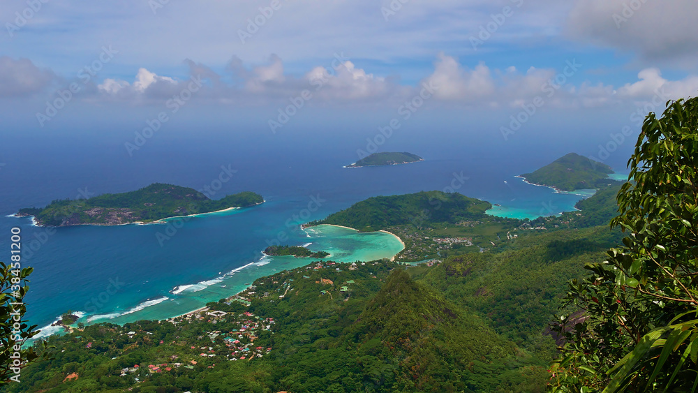 Panorama view from the top of mountain Morne Blanc, Mahe, Seychelles over the northwestern coastline of the island with tropical beach Anse l'Islette and Port Launay with turquoise colored water.