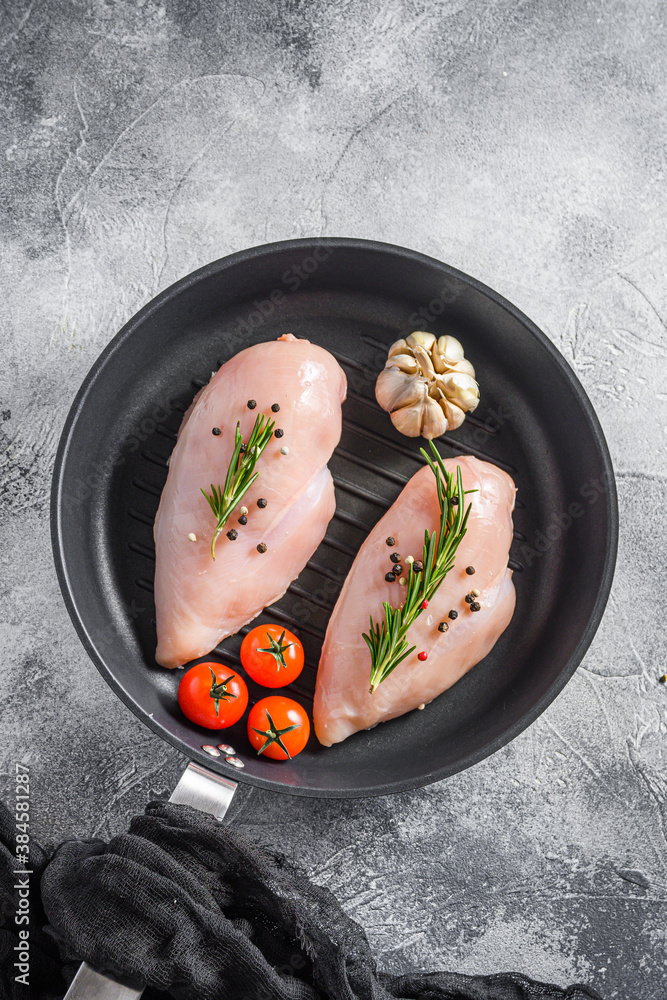  Raw organic chicken breastin grill pan on a grey background. Food preparation, top view.