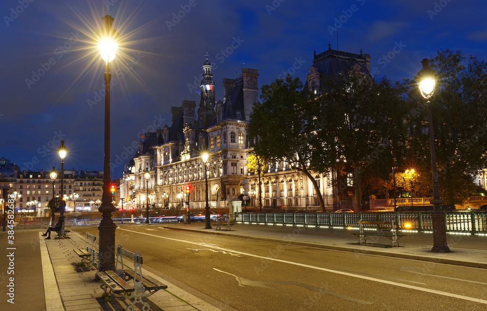 City Hall of Paris and bridge Arcole across Seine river at night, France.