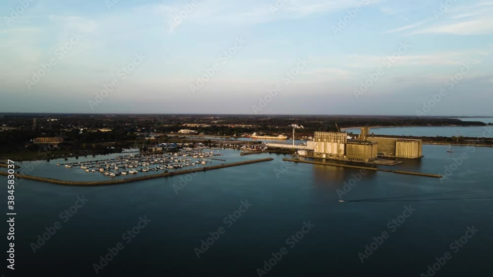 Aerial view of a motorboat driving past a marina and port facilities on Lake Erie.