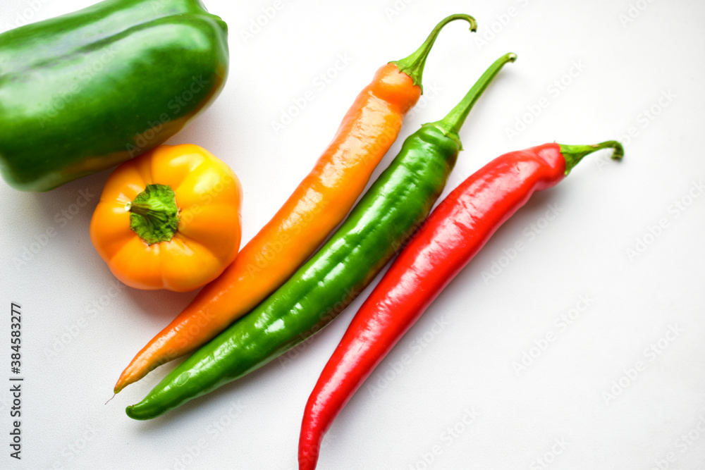 Regular and capsicum yellow and green pepper on a white background Regular and capsicum yellow and green pepper on a white background