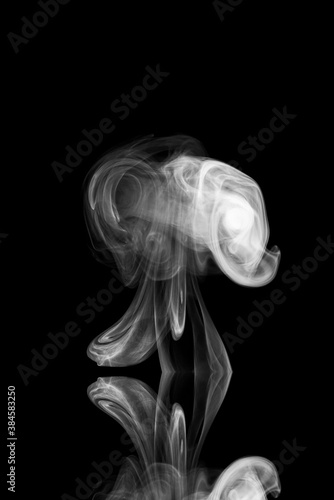 Fototapeta Naklejka Na Ścianę i Meble -  Clouds of white smoke on a black background, movement of smoke, smoke in the shape of a jellyfish