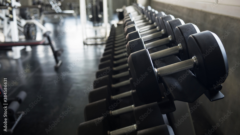 Obraz premium metal dumbbells on rack at fitness gym