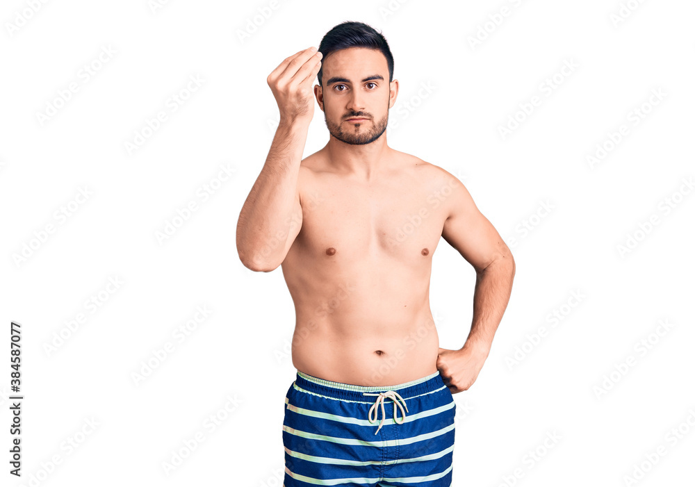 Fototapeta premium Young handsome man wearing swimwear doing italian gesture with hand and fingers confident expression