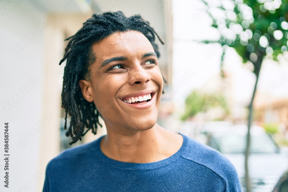 Young african american man smiling happy looking to the side at street of city. Young african american man smiling happy looking to the side at street of city.