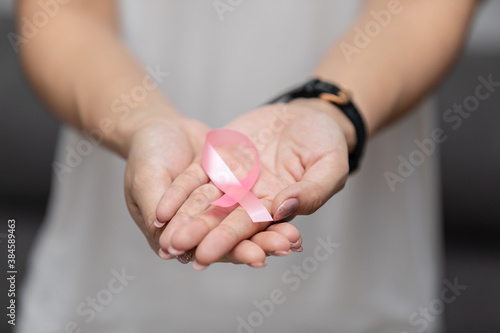 woman holding pink ribbon to support breast cancer awareness month for fight with cancer