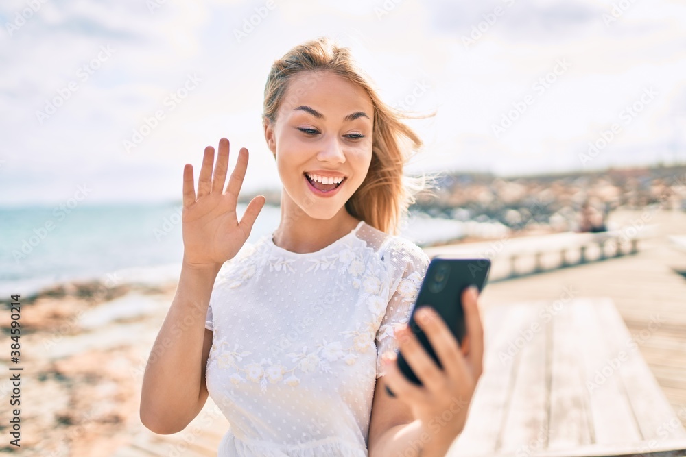 Young caucasian girl smiling happy doing video call using smartphone at street of city.