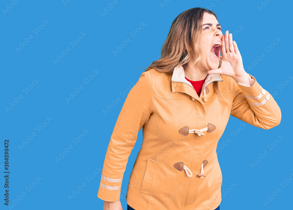 Young caucasian woman wearing casual clothes shouting and screaming loud to side with hand on mouth. communication concept. Young caucasian woman wearing casual clothes shouting and screaming loud to side with hand on mouth. communication concept.