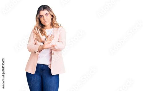 Young caucasian woman wearing business clothes rejection expression crossing arms doing negative sign, angry face