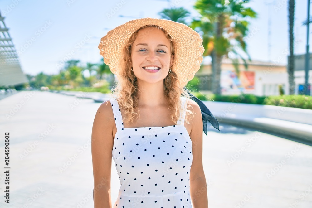 Young beautiful caucasian woman with blond hair smiling happy outdoors on a summer day