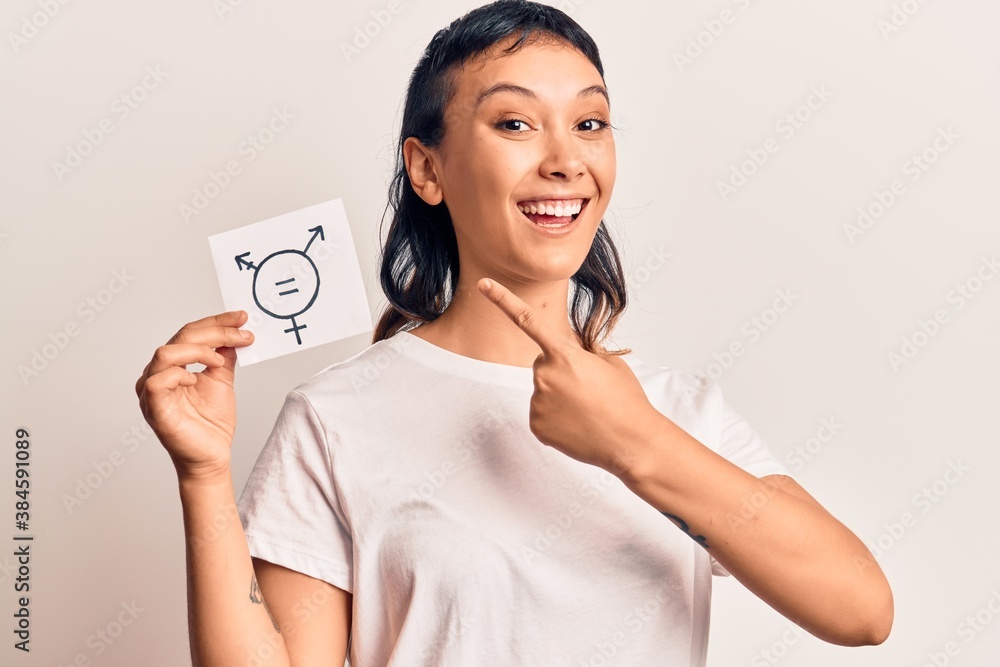 Young woman holding transgender symbol reminder smiling happy pointing with hand and finger Young woman holding transgender symbol reminder smiling happy pointing with hand and finger
